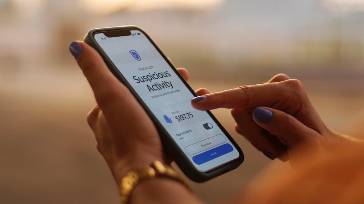 Phone with Visa Secure logo showing a Suspicious Activity notice.