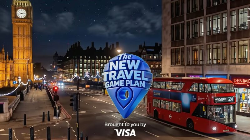Night view of London featuring Big Ben and a red double-decker bus. The sky is starry, with the text "The New Travel Game Plan" and "Brought to you by Visa."