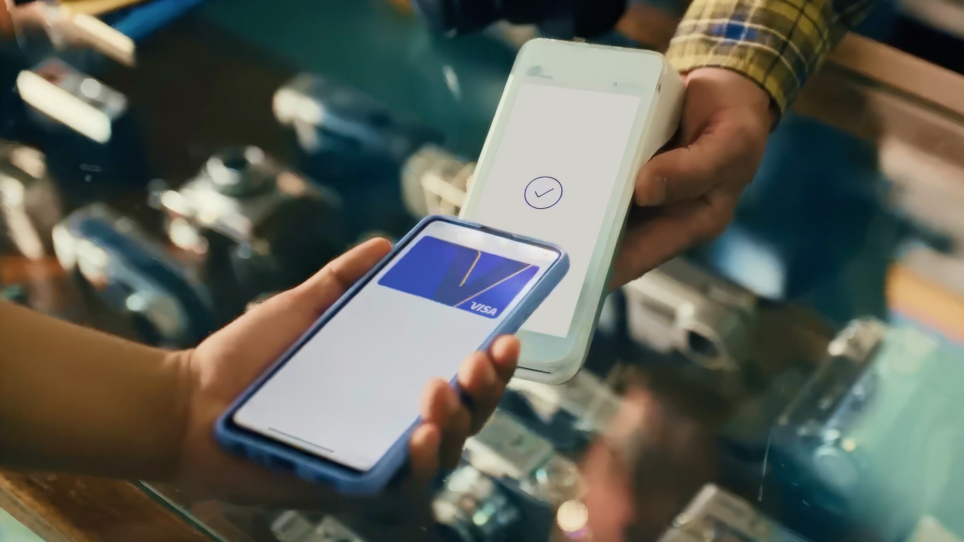 Paying at card reader with phone showing a Visa-branded card.