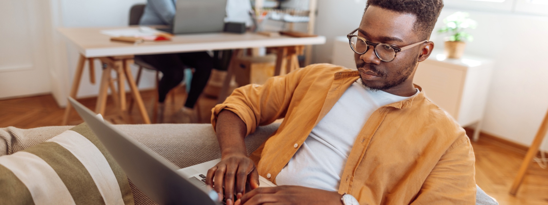Man using laptop on couch mobile