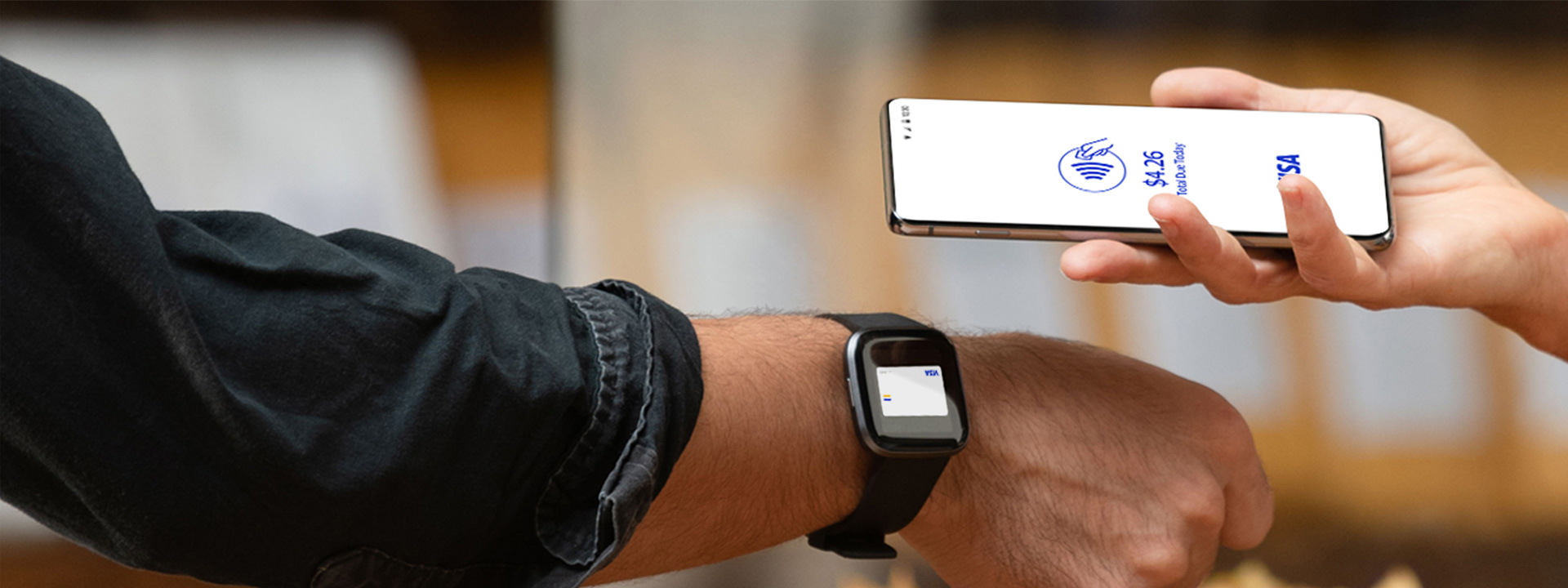 Smartwatch sendo aproximado do celular para pagamento