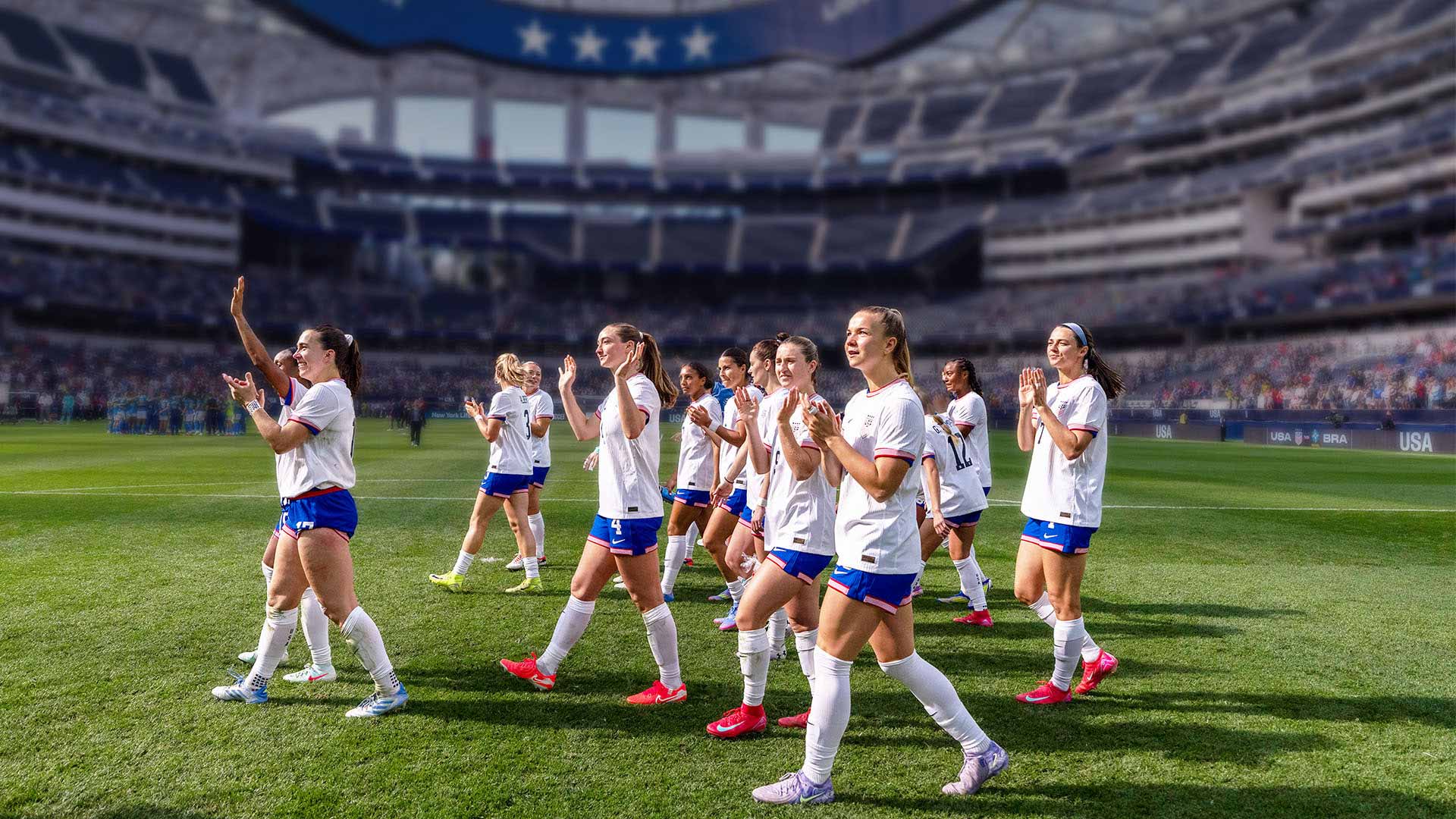 US Women’s National Soccer Team walks across a field in a stadium.