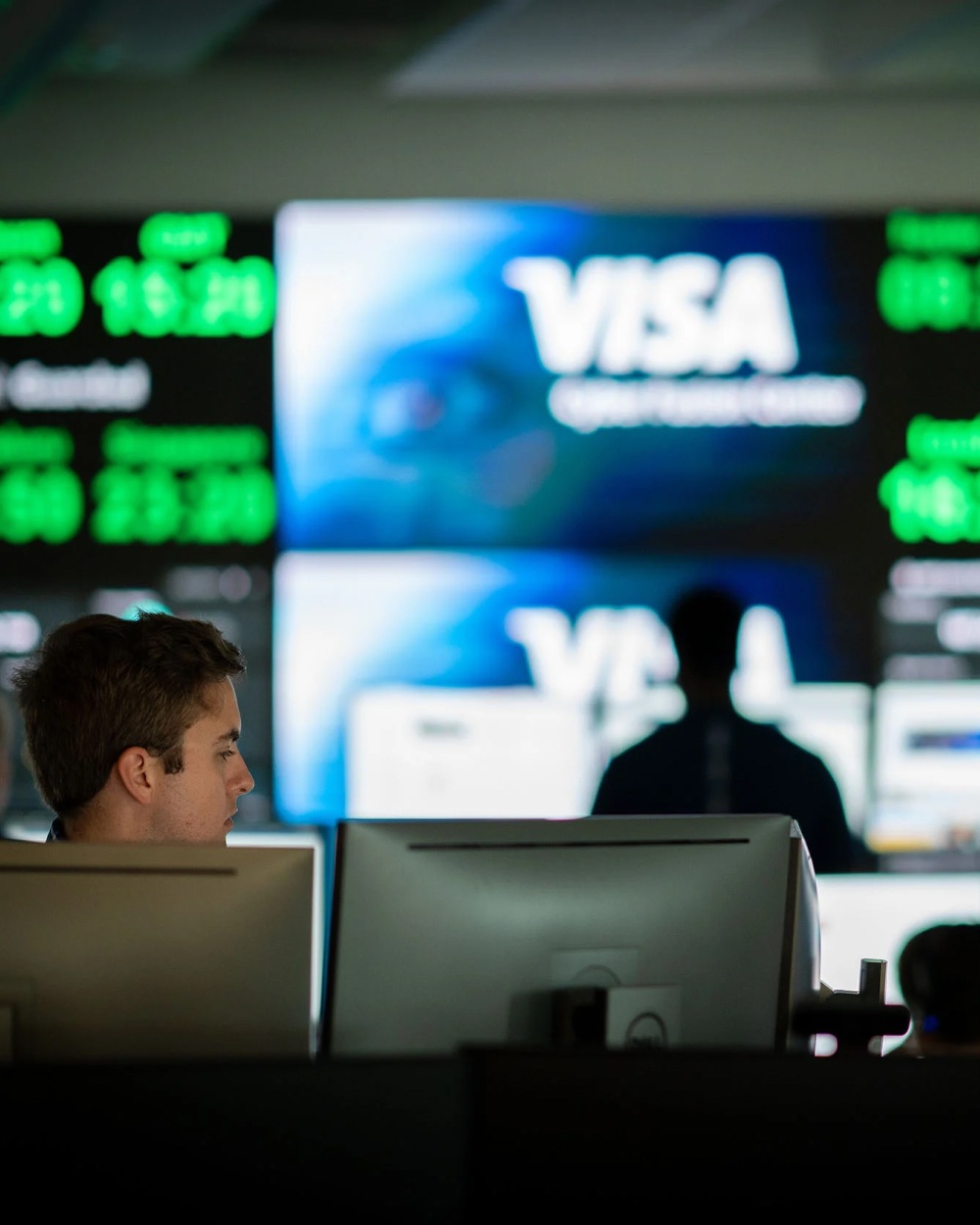 Group work area with Visa logo on screens in the background.