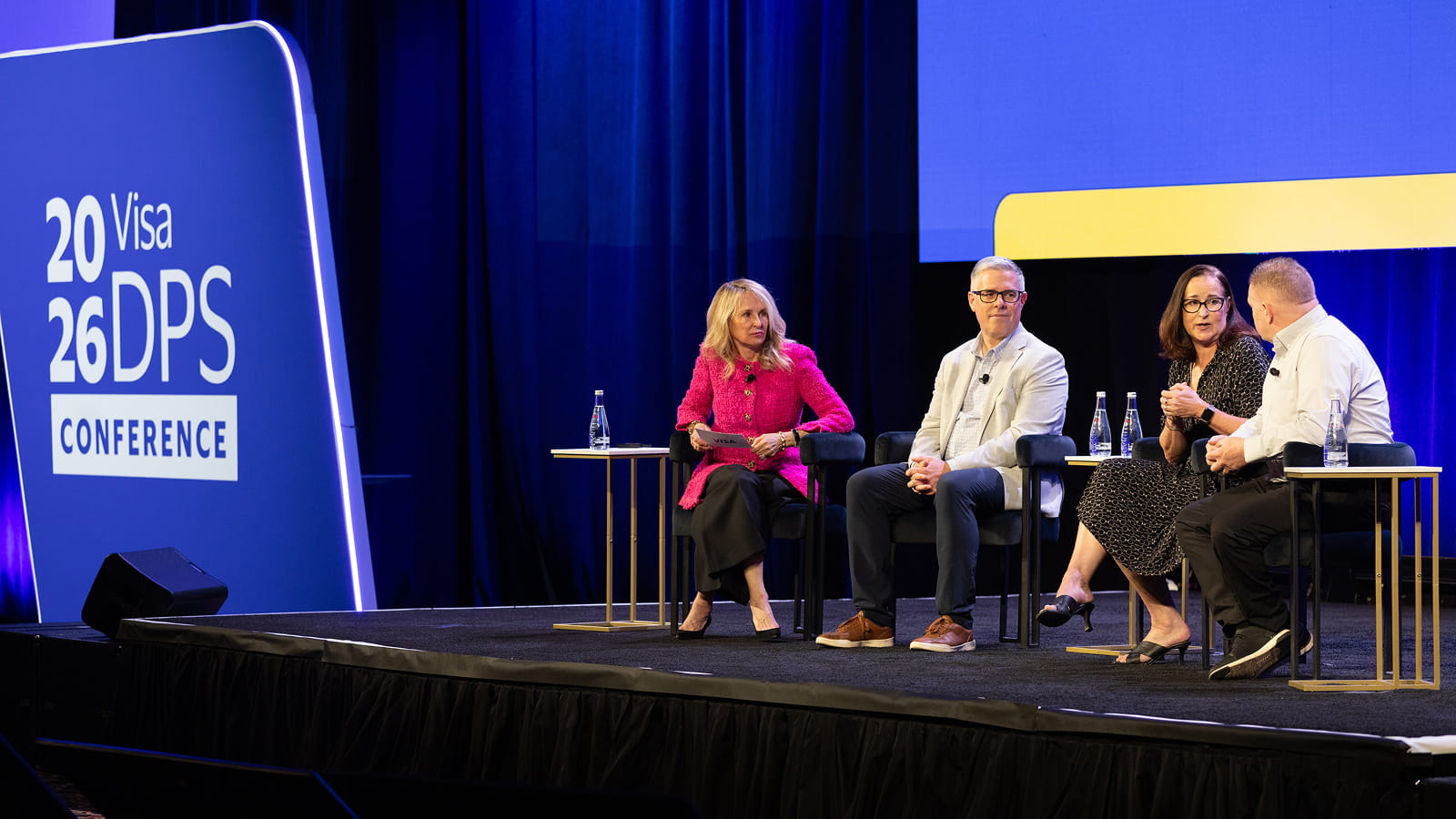 Karen Webster, founder and CEO of PYMNTS, facilitating a panel of three speakers on stage